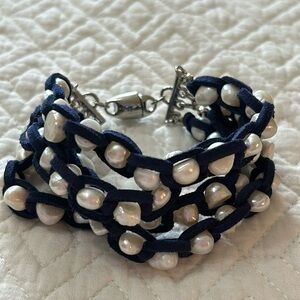 Four stands of faux pearls wrapped in blue faux suede bracelet.